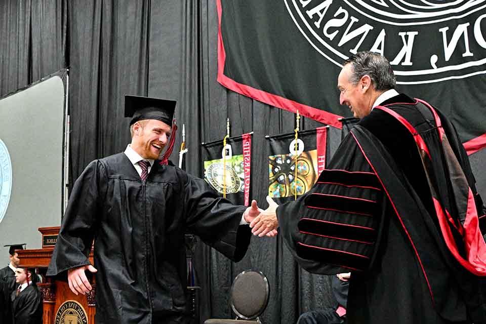 A student shakes President Minnis' hand during Commencement